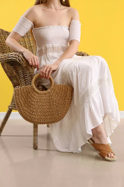 Elegant Woman Sitting Chair Holding Stylish Rattan Handbag Yellow Background — Stock Fotó