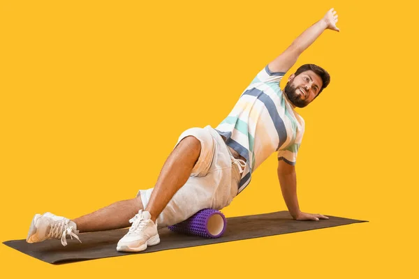 Young Man Training Foam Roller Yellow Background — Stockfoto
