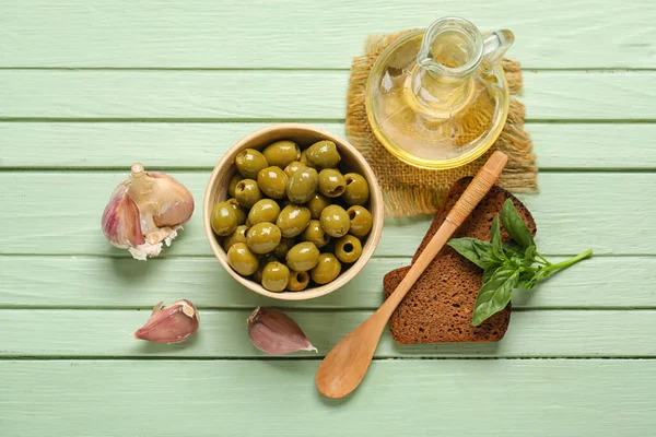 Composition Bowl Tasty Green Olives Oil Bread Garlic Color Wooden — Stockfoto