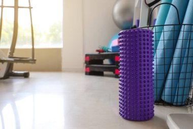 Purple foam roller on floor in gym
