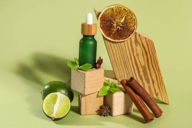 Composition with bottle of essential oil, spices and wooden decor on color background