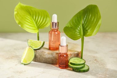 Bottles of essential oil and cucumber slices on table