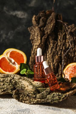 Composition with bottles of essential oil and tree bark on table