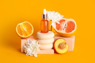 Composition with bottle of essential oil, fruits, flowers and plaster stands on color background