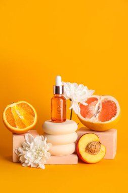 Composition with bottle of essential oil, fruits, flowers and plaster stands on color background