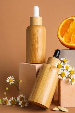 Composition with bottles of essential oil, chamomile flowers and plaster decor on color background, closeup