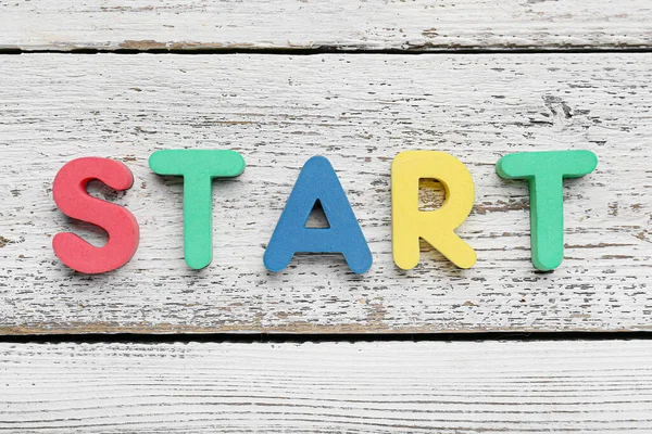 Word START on white wooden background