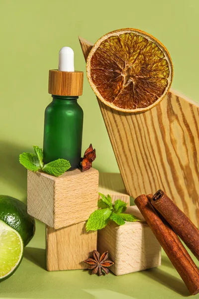 Composition with bottle of essential oil, spices and wooden decor on color background