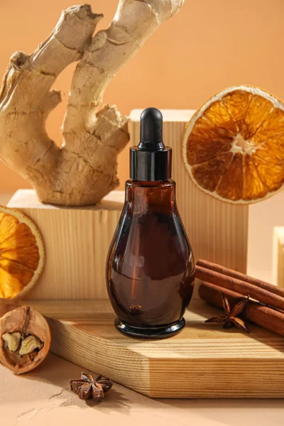 Composition with bottle of essential oil and wooden decor on table, closeup