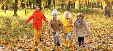 Sonbahar parkında oynayan şirin çocuklar.