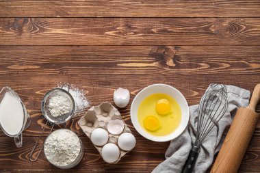 Composition with different ingredients for baking on wooden background