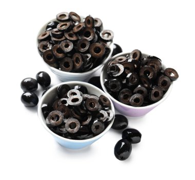 Bowls of cut black olives on white background