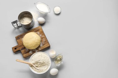Set of ingredients for baking with raw dough on white background