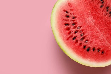 Half of tasty watermelon on pink background