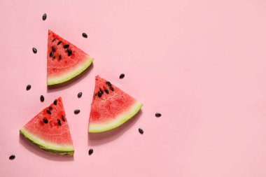 Slices of tasty watermelon with seeds on pink background