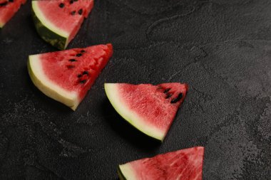 Slices of tasty watermelon on dark background