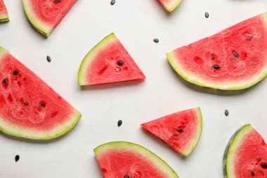 Slices of watermelon and seeds on white background