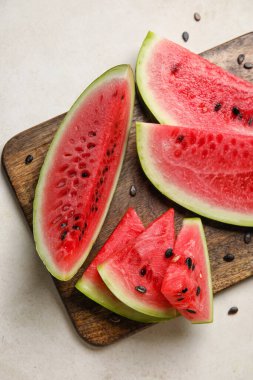 Cutting board with slices of watermelon on white background