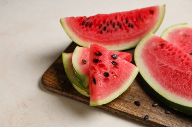 Cutting board with slices of watermelon on white background, closeup
