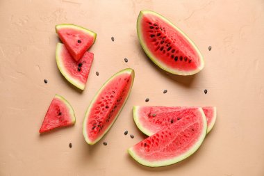 Slices of watermelon with seeds on beige background