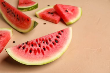 Slices of watermelon with seeds on beige background