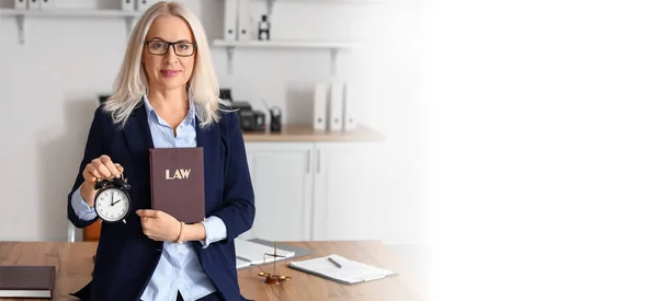 Mature female judge with alarm clock and law book in office. Banner for design