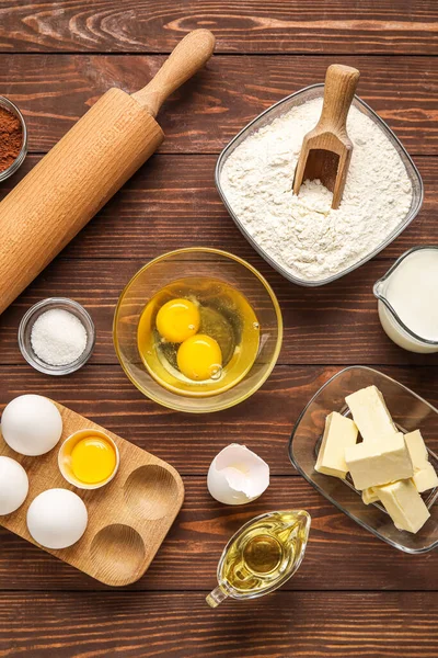 Different ingredients for baking on wooden background