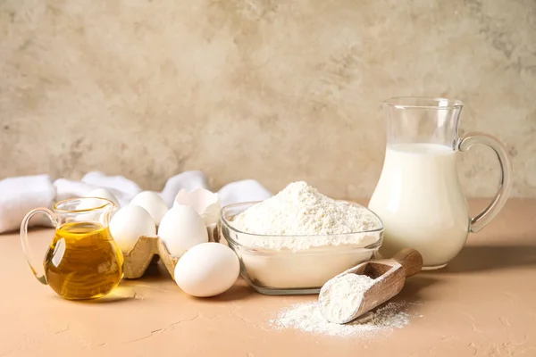 Different ingredients for baking on table against beige background