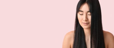 Young Asian woman with beautiful long hair on pink background with space for text