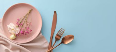 Beautiful table setting with flowers on blue background with space for text