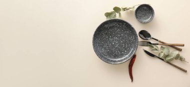 Table setting with eucalyptus branches on light background with space for text, top view