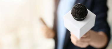 Ofisinde mikrofonu olan kadın gazeteci, yakın plan.