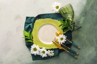 Elegant table setting with chamomile flowers on white and green background
