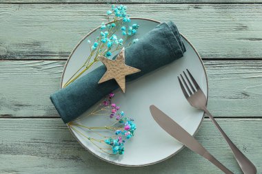 Beautiful table setting with gypsophila flowers on color wooden background