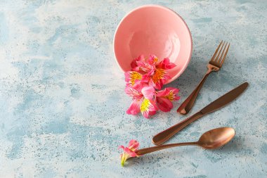 Table setting with beautiful alstroemeria flowers on blue background