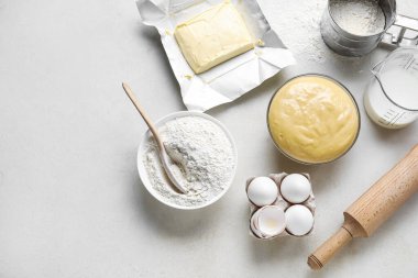 Set of ingredients for baking with rolling pin on light background