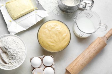 Set of ingredients for baking with rolling pin on light background
