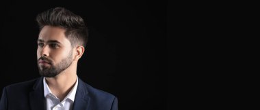 Handsome young man with stylish hairdo on dark background with space for text