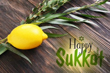 Greeting card with Sukkot festival symbols on wooden background