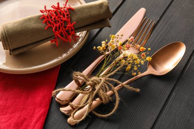 Stylish table setting with floral decor on dark wooden background