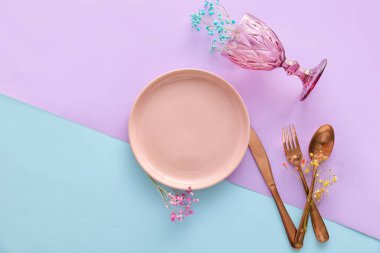 Table setting with floral decor on color background