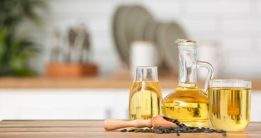 Glassware of sunflower oil and seeds on kitchen table