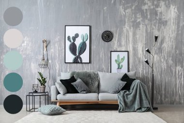 Stylish interior of room with grey sofa and floor lamp. Different color patterns