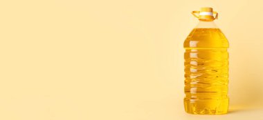 Bottle of sunflower oil on light beige background with space for text