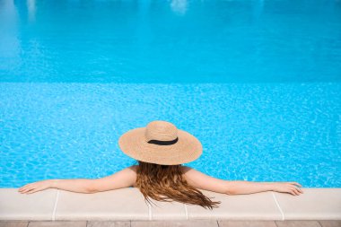 Young woman with hat in swimming pool
