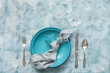 Beautiful table setting and gypsophila flowers on blue background