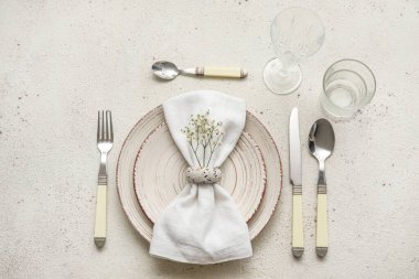 Elegant table setting with gypsophila flowers on light background