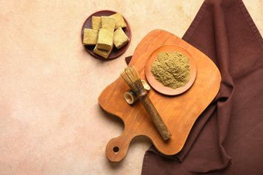 Plates with tasty marshmallows, hojicha powder and chasen on beige background