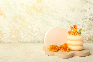 Plaster podiums with alstroemeria flowers on light table