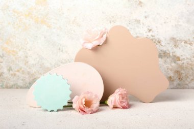 Plaster podiums with eustoma flowers on light table